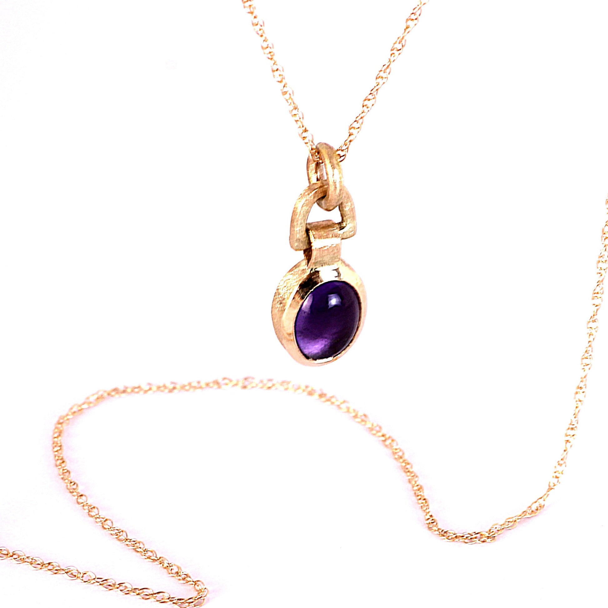 A Solid 14k gold necklace, featuring a smooth, 8x6mm oval purple Amethyst gemstone, displayed on a clean white background.