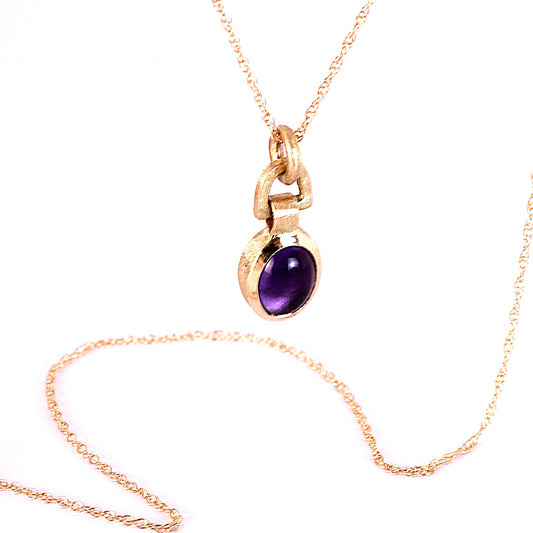A Solid 14k gold necklace, featuring a smooth, 8x6mm oval purple Amethyst gemstone, displayed on a clean white background.